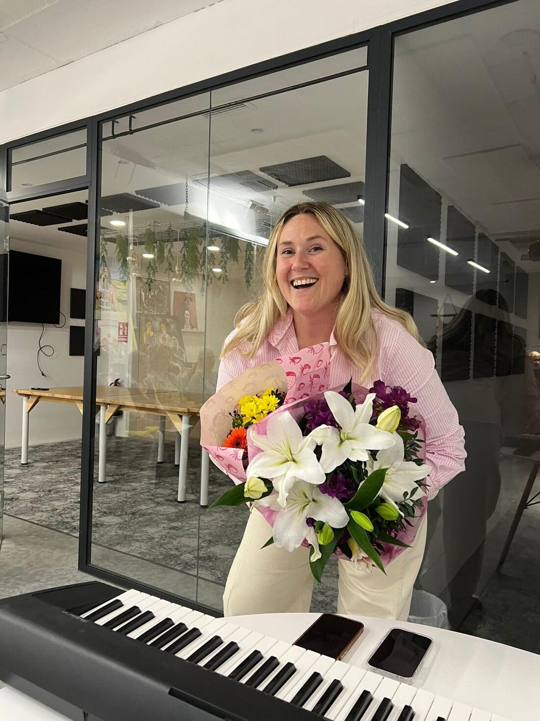 Georgie smiling with a bouquet of flowers at choir rehearsal
